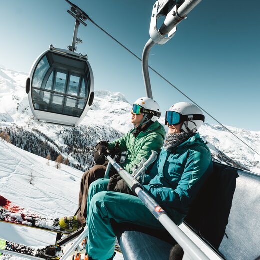 zwei Skifahrer im Sessellift im Skigebiet Zermatt