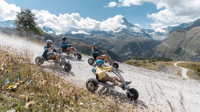 Four friends riding mountaincarts in front of the Matterhorn | © BasicHomeProduction