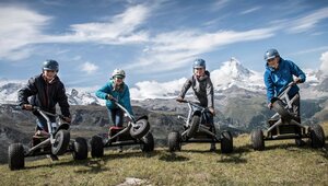 Four friends having fun with their mountaincarts in front of the Matterhorn | © Leander Wenger